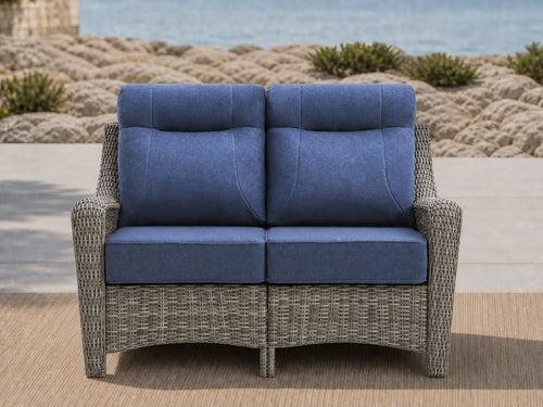 OuterCraft dark PE rattan outdoor loveseat featuring 6-inch thick blue cushions styled by the coast.