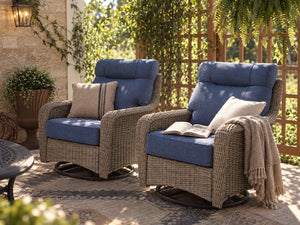 OuterCraft dark PE rattan swivel rocker chairs with blue cushions on a luxury patio deck.