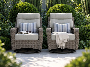 OuterCraft dark PE rattan swivel rocker chairs with light gray cushions in a lush garden estate.