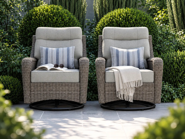 OuterCraft dark PE rattan swivel rocker chairs with light gray cushions in a lush garden estate.