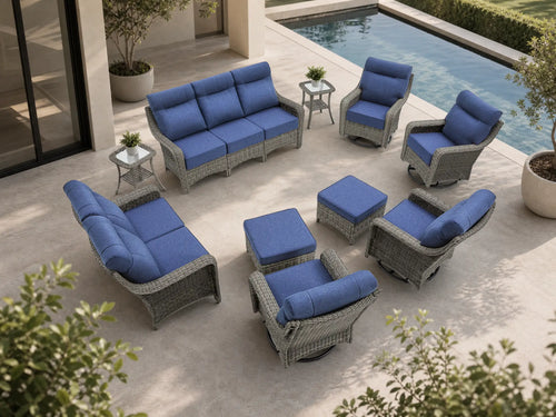 OuterCraft 10-piece dark PE rattan patio set with 3-seater sofa, loveseat, 360-degree swivel rocker chairs, ottomans and side tables with 6-inch thick blue cushions styled on a grand estate patio