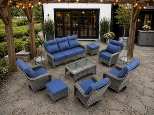 OuterCraft 10-piece dark PE rattan patio furniture set with 3-seater sofas, swivel rocker chairs, ottomans and blue cushions styled on a grand estate patio