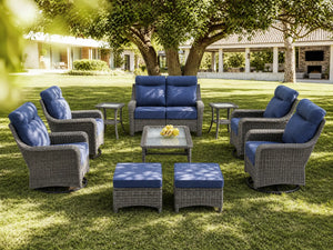 OuterCraft 10-piece dark PE rattan patio set with loveseat, 360-degree swivel rocker chairs, ottomans, side table and coffee table set with 6-inch thick blue cushions styled on a grand estate patio