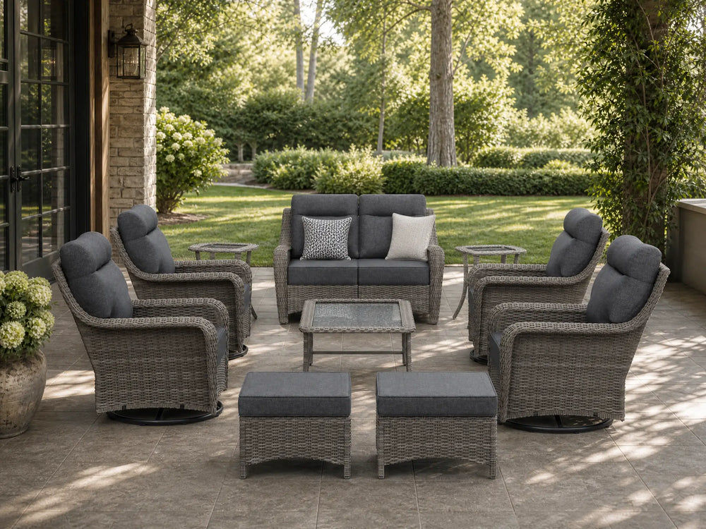 OuterCraft 10-piece dark PE rattan patio set with loveseat, 360-degree swivel rocker chairs, ottomans, side table and coffee table set with 6-inch thick blue cushions styled on a grand estate patio