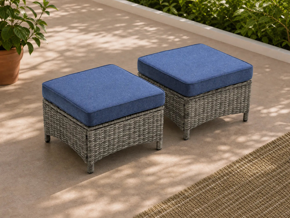 OuterCraft dark PE rattan hand-woven ottomans with thick blue cushions styled on a grand estate patio