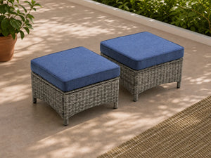 OuterCraft dark PE rattan hand-woven ottomans with thick blue cushions styled on a grand estate patio