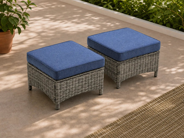 OuterCraft dark PE rattan hand-woven ottomans with thick blue cushions styled on a grand estate patio