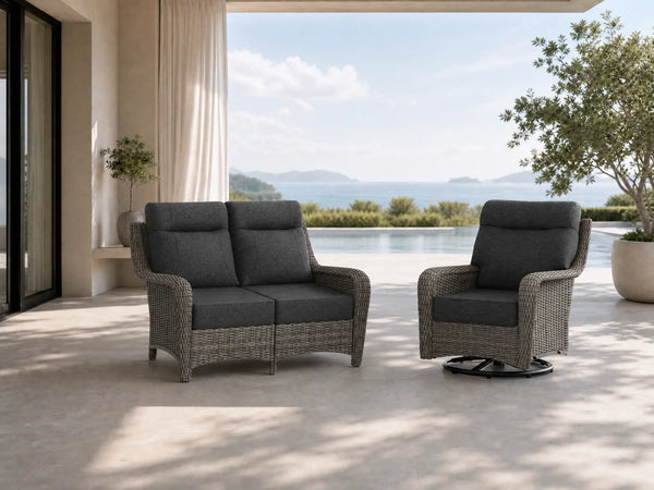 OuterCraft dark PE rattan loveseat and 360-degree swivel rocker chairs with 6-inch thick dark gray cushions styled on a grand estate patio