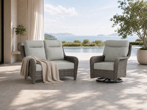 OuterCraft dark PE rattan loveseat and 360-degree swivel rocker chairs with 6-inch thick light gray cushions styled on a grand estate patio