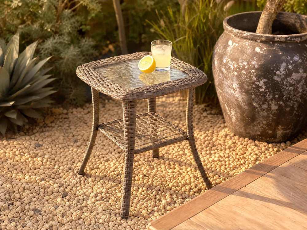 OuterCraft 2-tier dark PE wicker side table with tempered glass top and lower storage shelf styled on gravel patio