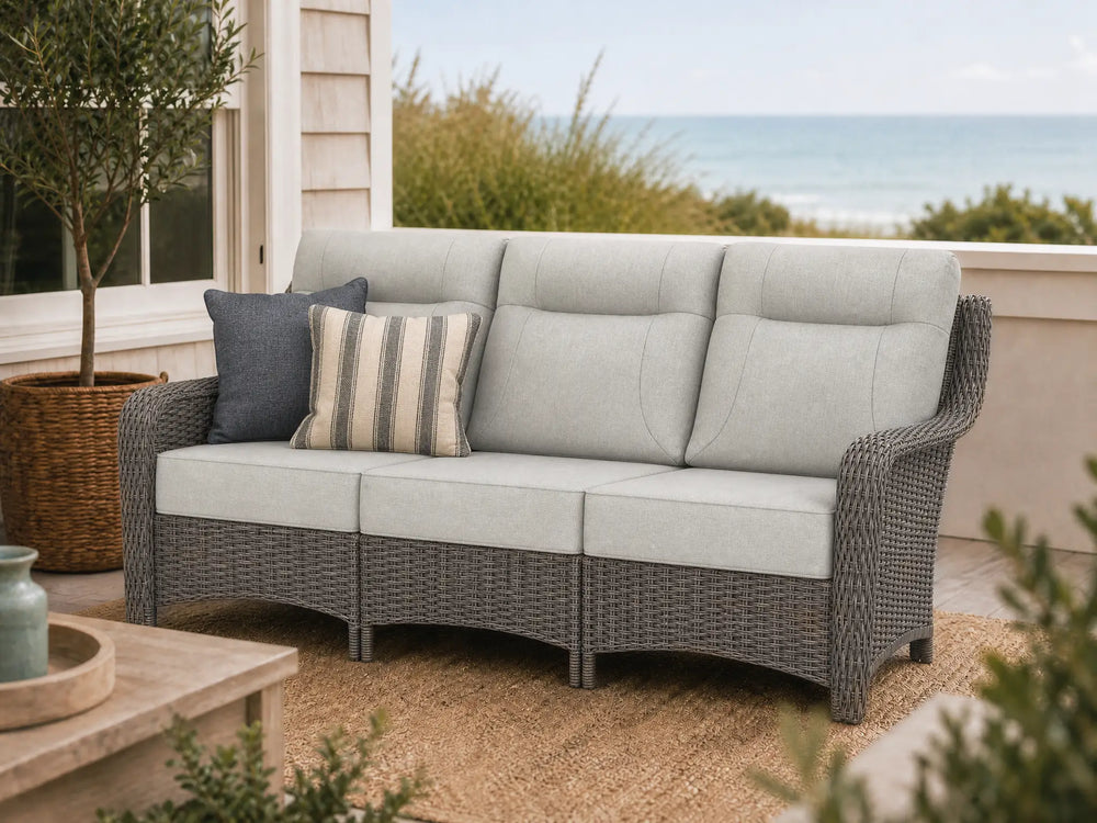 OuterCraft 3-seater all-weather dark PE wicker sofa with 6-inch thick light gray cushions on a grand estate patio
