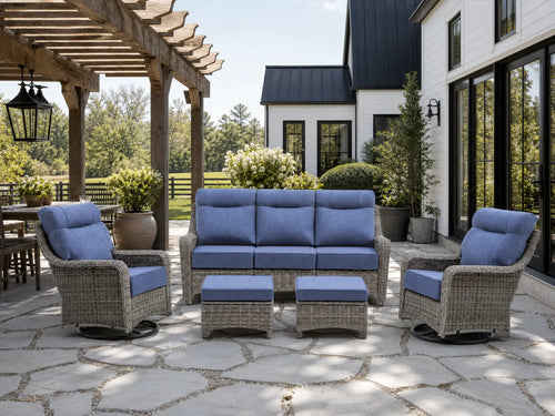 OuterCraft 5-piece dark PE rattan patio set with 3-seater sofa, 360-degree swivel rocker chairs and ottomans set with 6-inch thick blue cushions styled on a grand estate patio