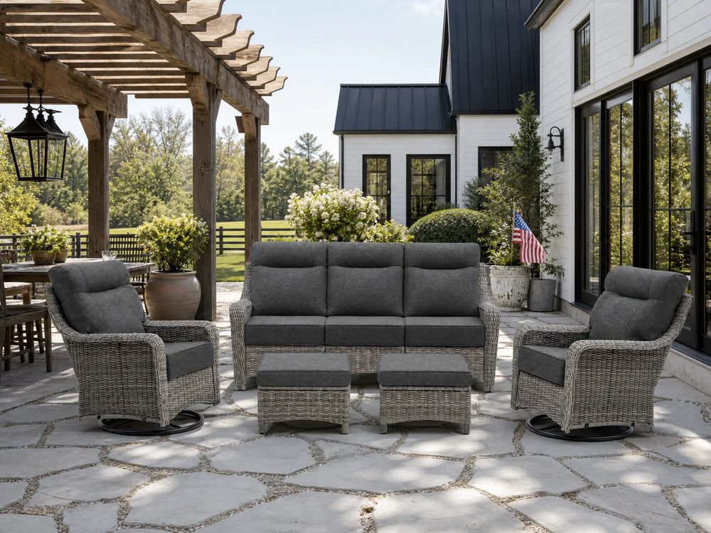 OuterCraft 5-piece dark PE rattan patio set with 3-seater sofa, 360-degree swivel rocker chairs and ottomans set with 6-inch thick dark gray cushions styled on a grand estate patio
