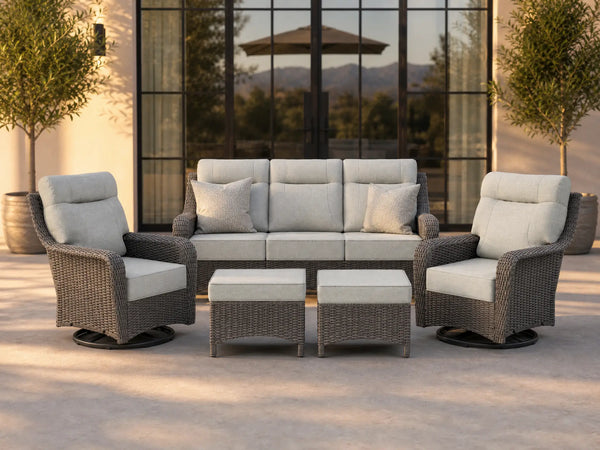OuterCraft 5-piece dark PE rattan patio set with 3-seater sofa, 360-degree swivel rocker chairs and ottomans set with 6-inch thick light gray cushions styled on a grand estate patio
