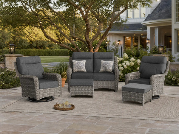 OuterCraft 5-piece dark PE rattan patio set with loveseat, 360-degree swivel rocker chairs and ottomans set with 6-inch thick dark gray cushions styled on a grand estate patio