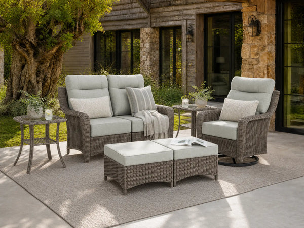 OuterCraft 6-piece dark PE rattan patio set with loveseat, 360-degree swivel rocker chairs, ottomans and side table set with 6-inch thick light gray cushions styled on a grand estate patio