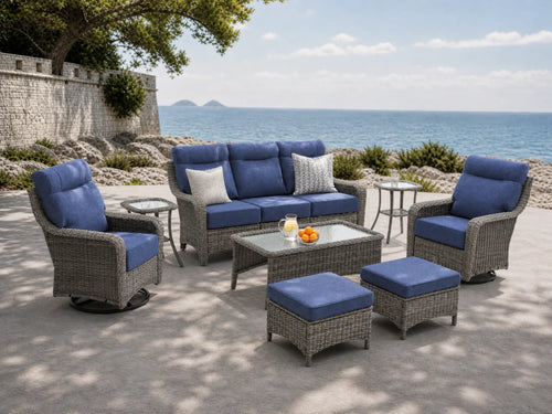 OuterCraft 8-piece dark PE rattan patio set with 3-seater sofa, 360-degree swivel rocker chairs, ottomans, side table and coffee table set with 6-inch thick blue cushions styled on a grand estate patio