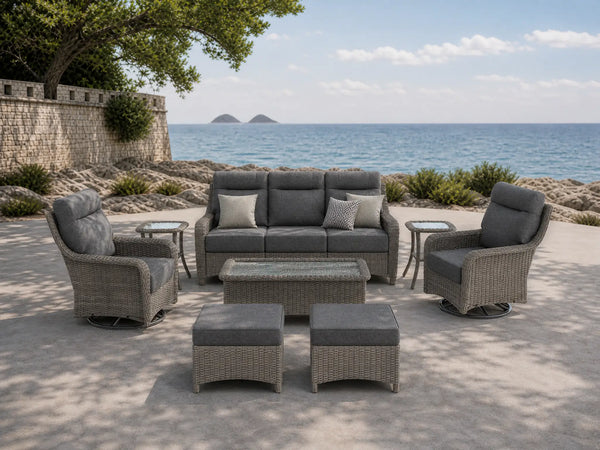 OuterCraft 8-piece dark PE rattan patio set with 3-seater sofa, 360-degree swivel rocker chairs, ottomans, side table and coffee table set with 6-inch thick dark gray cushions styled on a grand estate patio