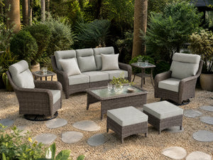OuterCraft 8-piece dark PE rattan patio set with 3-seater sofa, 360-degree swivel rocker chairs, ottomans, side table and coffee table set with 6-inch thick light gray cushions styled on a grand estate patio