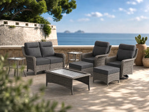 OuterCraft 8-piece dark PE rattan patio set with loveseat, 360-degree swivel rocker chairs, ottomans, coffee table and side table set with 6-inch thick dark gray cushions styled on a grand estate patio