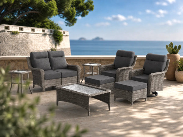OuterCraft 8-piece dark PE rattan patio set with loveseat, 360-degree swivel rocker chairs, ottomans, coffee table and side table set with 6-inch thick dark gray cushions styled on a grand estate patio