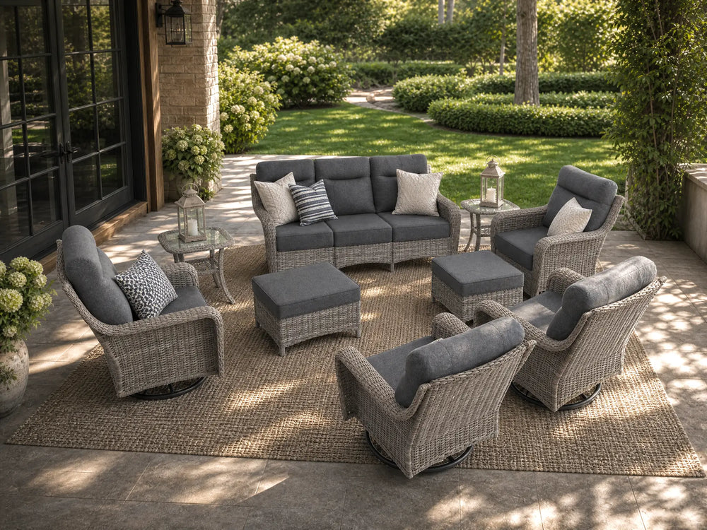 OuterCraft 9-piece dark PE rattan patio furniture set with 3-seater sofa, swivel rocker chairs, ottomans, side tables and light gray cushions styled on a grand estate patio