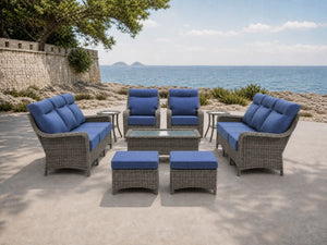 OuterCraft 9-piece dark PE rattan patio set with 3-seater sofas, 360-degree swivel rocker chairs, ottomans, coffee table and side tables with 6-inch thick blue cushions styled on a grand estate patio