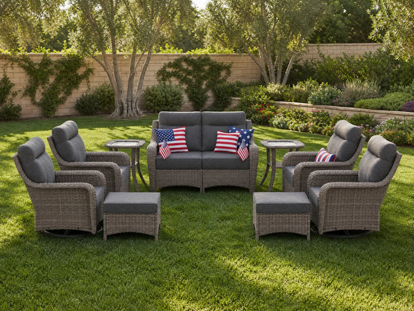 OuterCraft 9-piece dark PE rattan patio set with loveseat, 360-degree swivel rocker chairs, ottomans and side table set with 6-inch thick dark gray cushions styled on a grand estate patio
