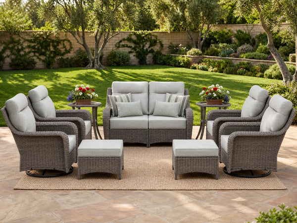 OuterCraft 9-piece dark PE rattan patio set with loveseat, 360-degree swivel rocker chairs, ottomans and side table set with 6-inch thick light gray cushions styled on a grand estate patio