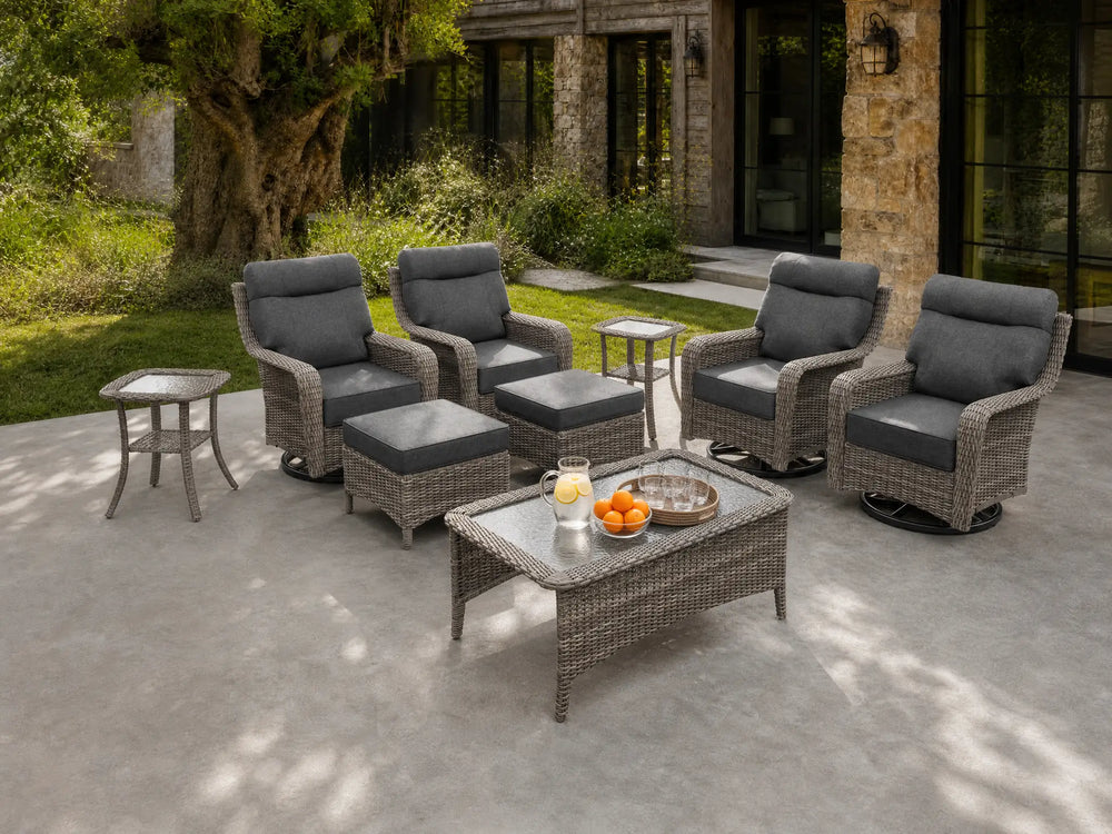 OuterCraft 9-piece dark PE rattan patio set with 360-degree swivel rocker chairs, ottomans, coffee table and side table set with 6-inch thick dark gray cushions styled on a grand estate patio