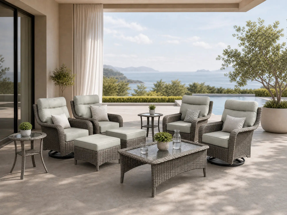 OuterCraft 9-piece dark PE rattan patio set with 360-degree swivel rocker chairs, ottomans, coffee table and side table set with 6-inch thick dark gray cushions styled on a grand estate patio