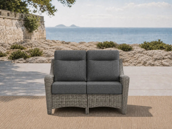 OuterCraft all-weather dark PE rattan loveseat and 6-inch thick dark gray cushions styled on a grand estate patio