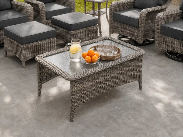 Close-up of OuterCraft dark PE wicker rectangle outdoor coffee table showing tempered glass top and hand-woven border detail