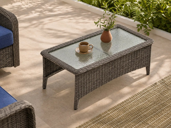 OuterCraft dark PE wicker rectangle outdoor coffee table with tempered glass top styled on sunlit patio