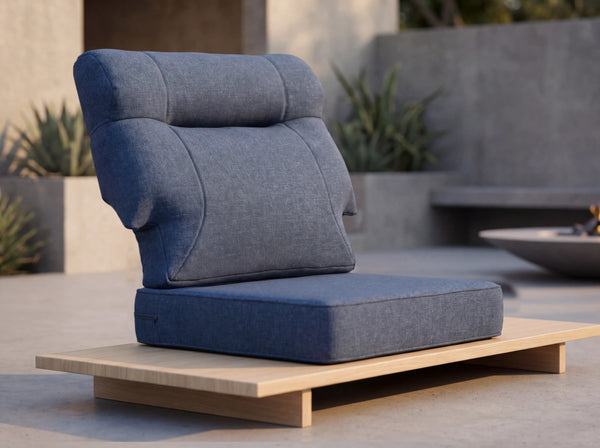 Close-up of OuterCraft ergonomic high-back outdoor cushion set in navy blue weather-resistant Olefin fabric on minimalist wooden platform