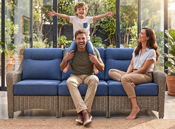 OuterCraft 3-seater wicker sofa with blue cushions showcased in a warm family lifestyle patio setting.