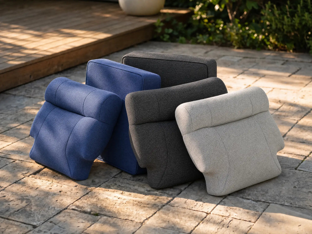 OuterCraft thick ergonomic outdoor cushions and backrests stacked on stone patio in blue, dark gray, and light gray